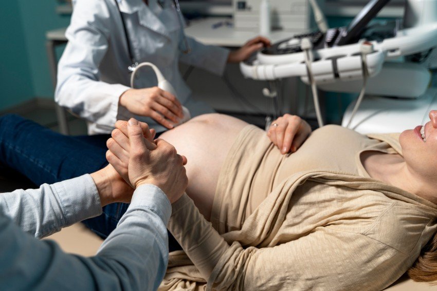 Pregnant woman receiving prenatal ultrasound examination from a doctor