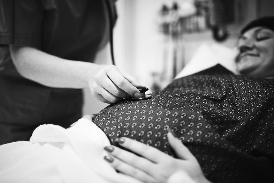 Obstetrician performing a prenatal checkup on a pregnant woman device to examine a pregnant woman’s abdomen during a prenatal appointment.